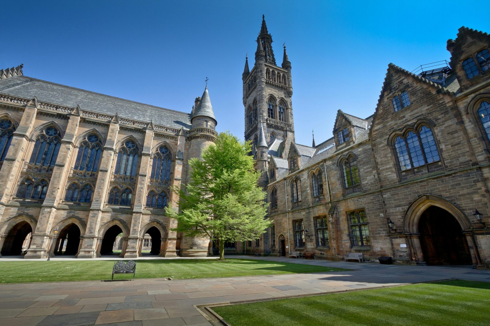 View of the stunning historic University of Glasgow courtyard under a clear blue sky.
